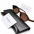 Yves Saint Laurent cat-eye sunglasses in tortoise shell with brown lenses, displayed on black leather YSL case with authenticity card