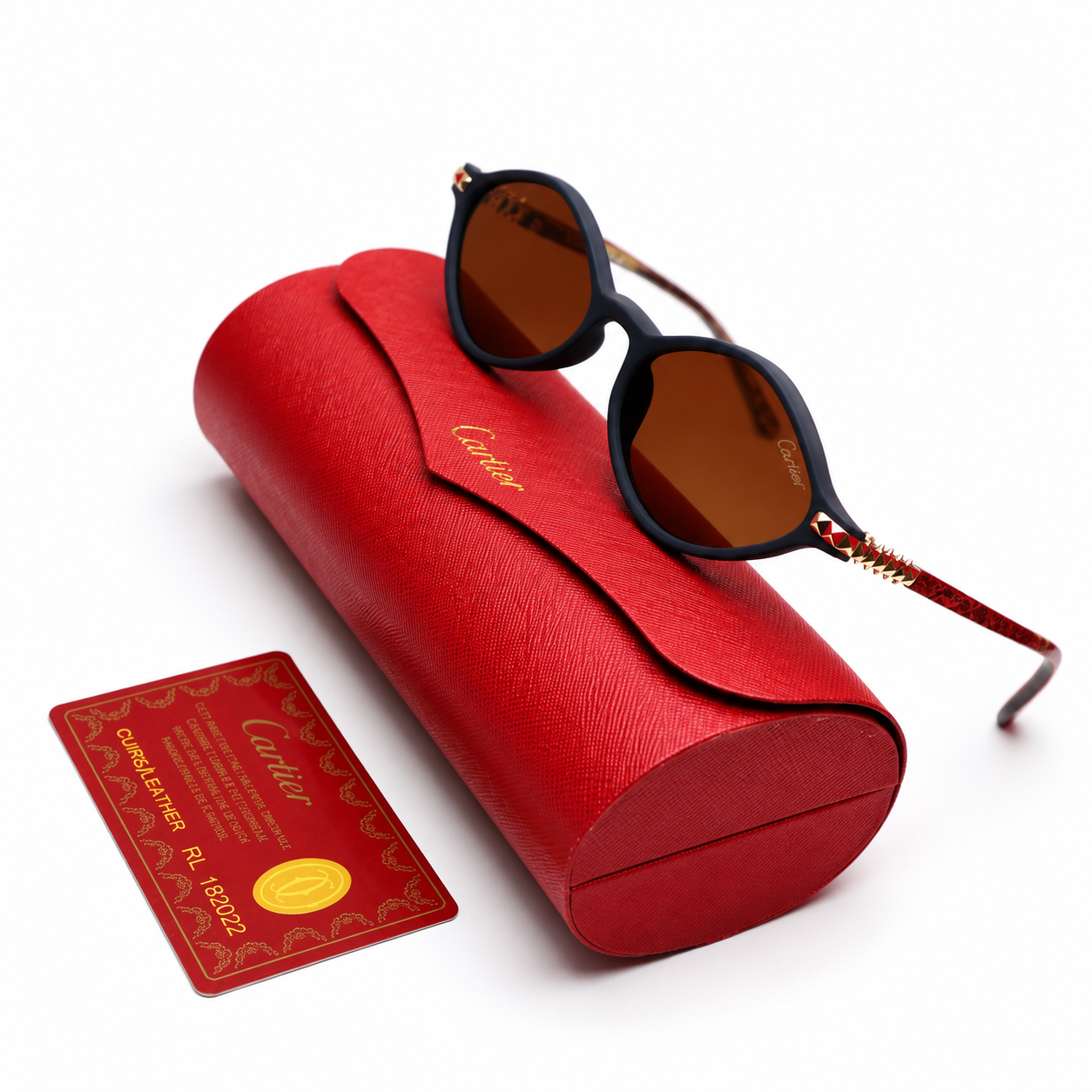 Cartier round sunglasses with matte black frame, brown lenses and red gold studded temples, displayed on red Cartier leather case with authenticity card