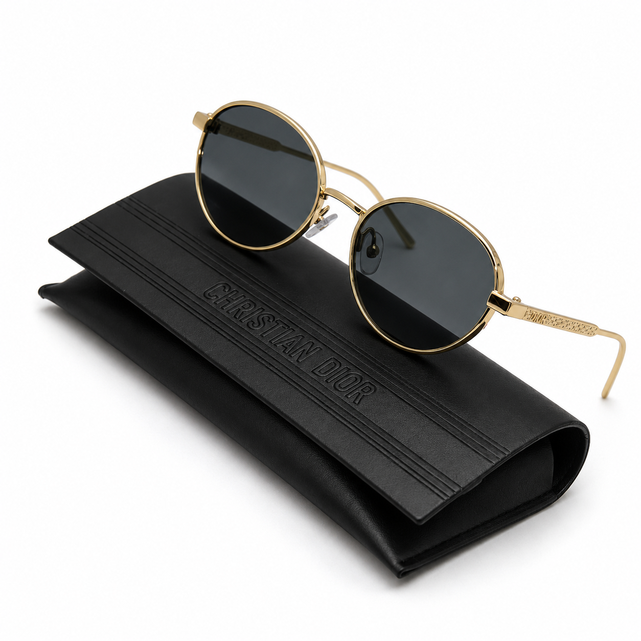 Christian Dior round sunglasses with gold metal frame and dark grey lenses, displayed on embossed black Christian Dior leather case