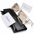 Yves Saint Laurent oversized square sunglasses in crystal clear acetate frame with champagne lenses, displayed on black YSL leather case with authenticity cards and cleaning cloth