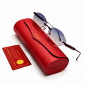 Cartier rimless round sunglasses with blue-grey gradient lenses and textured dark metal hardware, displayed on red Cartier leather case with authenticity card